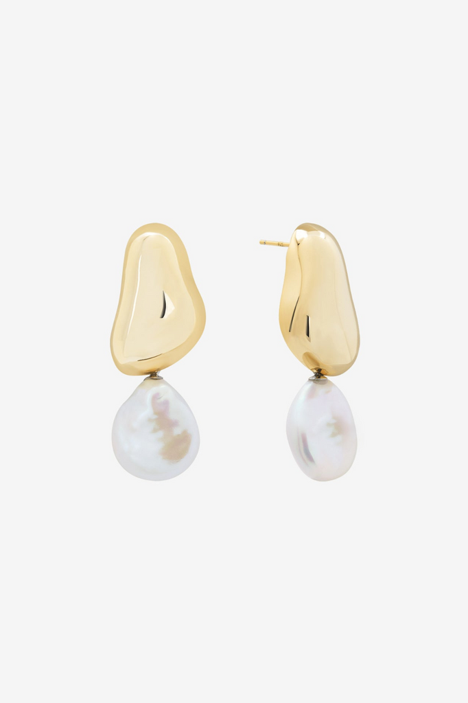 Gold earrings with pearl drops on a white background. Shashi Carter Pearl Drop Earring