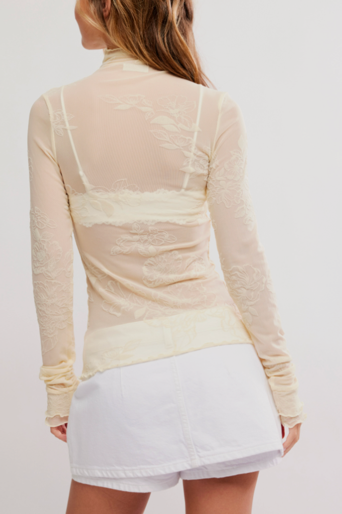 Sheer light yellow-hued long sleeve top with a lettuce trim