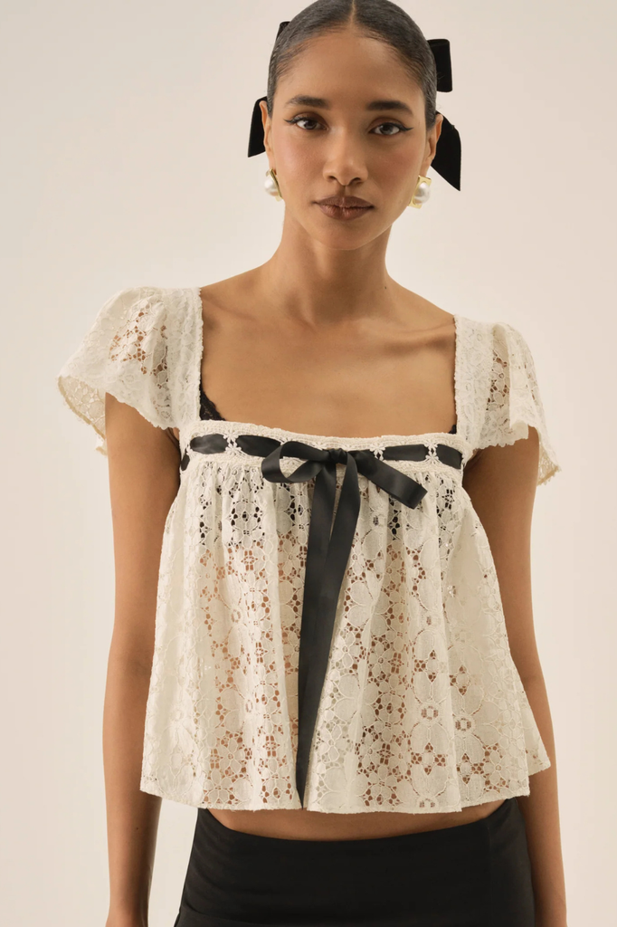 Dainty white lace blouse with square neckline and black ribbon accent