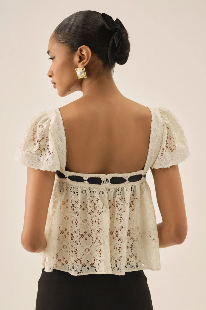 Dainty white lace blouse with square neckline and black ribbon accent