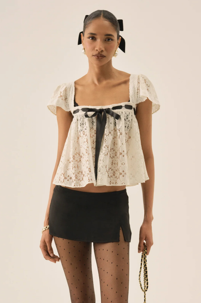 Dainty white lace blouse with square neckline and black ribbon accent