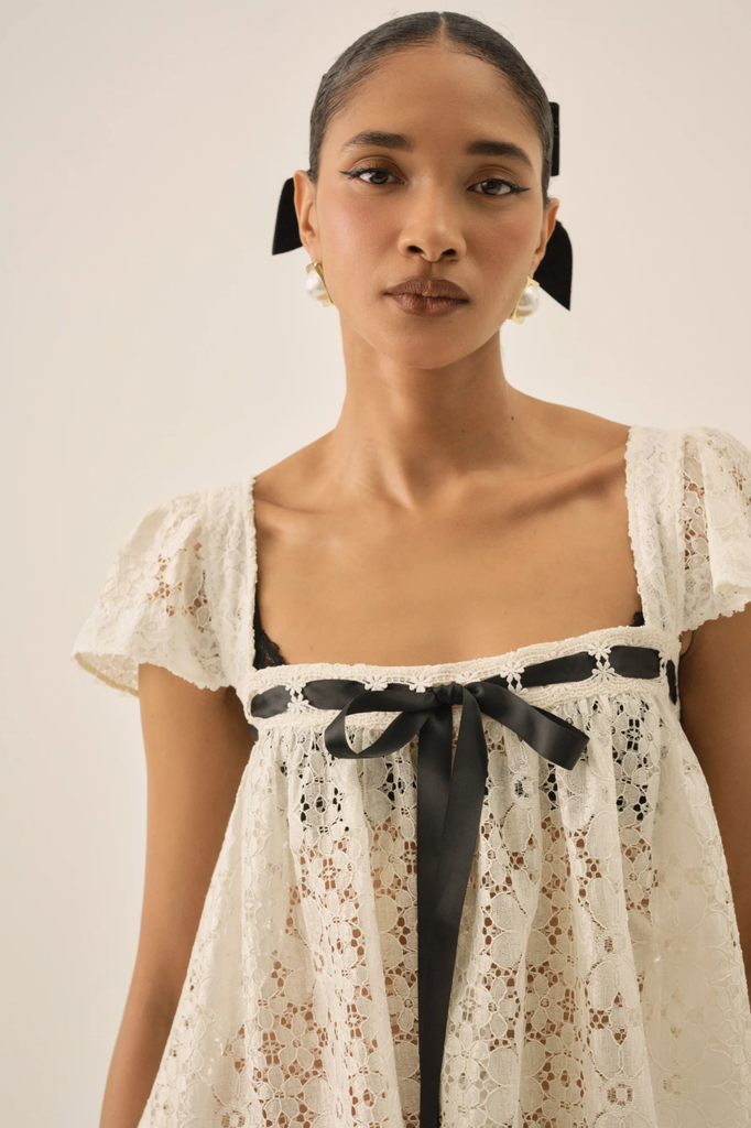 Dainty white lace blouse with square neckline and black ribbon accent